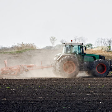 farming tractor using red diesel to plow field