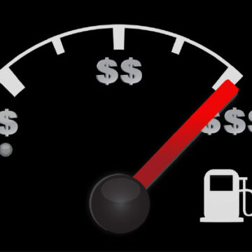 Close-up of a vehicle fuel gauge, with the levels labeled with dollar signs